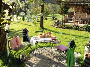 a picnic table and chairs in a garden with a table at Hansenbauernhof in Ruhpolding