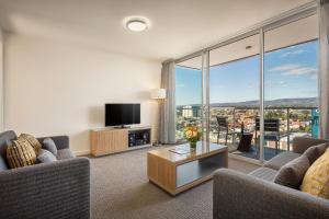 
a living room filled with furniture and a large window at Quest King William South in Adelaide
