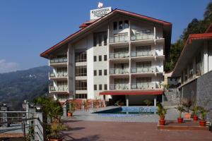 a hotel with a swimming pool in front of it at Yashshree Kanishka in Gangtok