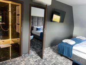 ルブリンにあるHotel Korona Spa & Wellnessのベッド2台と鏡が備わるホテルルームです。