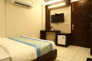 a bedroom with a bed and a flat screen tv at Hotel Kush Ganga - 50 Meter from Har ki Pauri, Haridwar in Haridwār