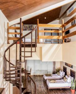 a living room with a spiral staircase and a couch at Yashshree Kanishka in Gangtok