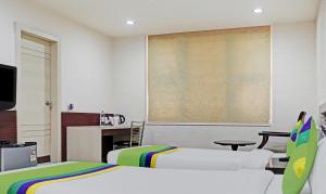 a bedroom with two beds and a large screen at Treebo Trend Elite City Upper Bazar in Rānchī