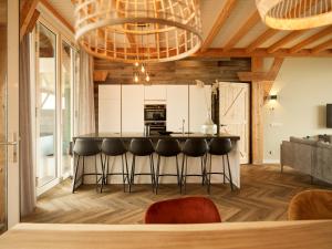 a kitchen with a bar with stools in a room at Dutchen Erfgoedpark De Hoop Vakantiewoningen in Uitgeest