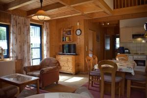 eine Küche und ein Wohnzimmer mit einem Tisch und Stühlen in der Unterkunft Ferienhaus Nr 9A3, Feriendorf Hagbügerl, Bayr Wald in Waldmünchen