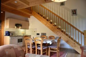 eine Küche mit einem Tisch und Stühlen sowie eine Treppe in der Unterkunft Ferienhaus Nr 9A3, Feriendorf Hagbügerl, Bayr Wald in Waldmünchen