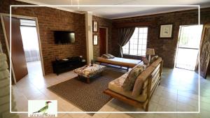 ein Wohnzimmer mit einer Couch und einem Sessel in der Unterkunft Uccellohouse in Marloth Park