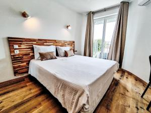 a bedroom with a large bed and a window at Hotel Du Lez in Bollène