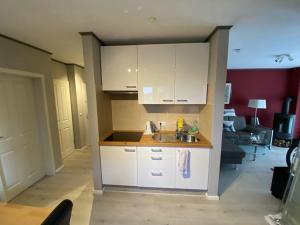 a kitchen with white cabinets and a sink in a room at Ferienwohnung-Starkwind in Lemkenhafen auf Fehmarn