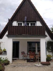 mały biały dom z drewnianym dachem i stołem w obiekcie Ferienwohnung Hansen in Hafennähe w mieście Kappeln