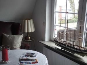 Zimmer mit einem Tisch und einem Modellschiff im Fenster in der Unterkunft Ferienwohnung Hansen in Hafennähe in Kappeln