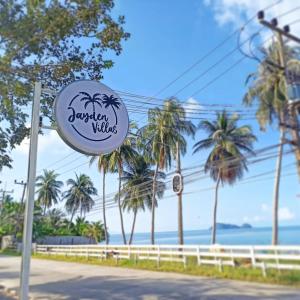 un cartello per un resort sulla spiaggia con palme di Jayden Villas a Hinkong