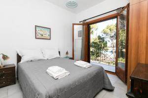 Кровать или кровати в номере Filyra Beachfront Villa