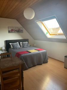 Schlafzimmer im Dachgeschoss mit einem Bett und einem Fenster in der Unterkunft Khon Thai's House Brugge in Brügge