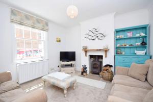 ein Wohnzimmer mit Couch und Kamin in der Unterkunft Seashell Cottage - Worthing in Worthing