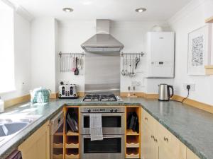 eine Küche mit Herd und Spüle in der Unterkunft Seashell Cottage - Worthing in Worthing