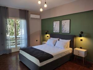 um quarto com uma cama grande e uma parede verde em Beautifull And Airy Appartment Corfu Town em Kanoni