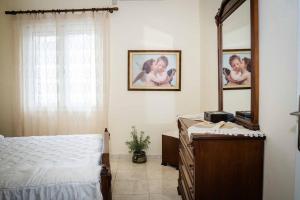 a bedroom with a mirror and a bed and a dresser at Kreta House in Pómbia