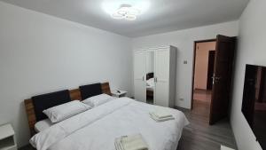 a bedroom with a large bed with white sheets at Focalize Apartament in Buzău