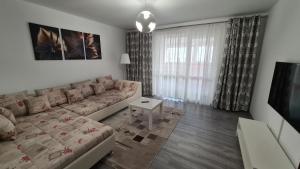 a living room with a couch and a table at Focalize Apartament in Buzău