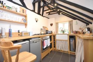 a large kitchen with wooden counters and a table at Rose Cottage, Middleton in Middleton-on-Sea