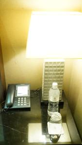 a cell phone sitting on top of a table next to a lamp at Quarantine Hotel - City Suites-Taipei Nanxi in Taipei