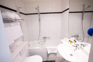 a white bathroom with a sink and a shower at The Ambassador in Geneva