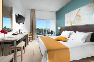a hotel room with a bed and a dining room at Mayfair Hotel formerly Smartline Paphos in Paphos City