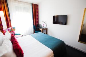 a hotel room with a bed and a tv at The Ambassador in Geneva