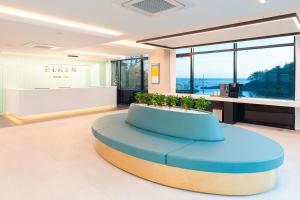 a lobby with a blue bench in the middle of a room at Elren Hotel Jeju in Seogwipo