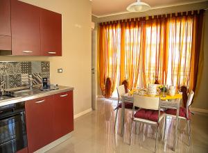 a kitchen with a table and chairs in a kitchen at La Conchiglia Case Vacanze in Balestrate
