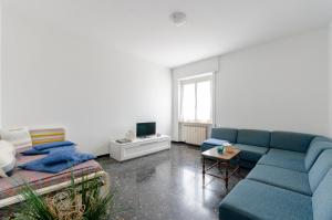 sala de estar con sofá azul y mesa en JOIVY Family Flat Terrace & Parking near Beach en Sestri Levante