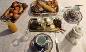 einen Tisch mit Teller mit Lebensmitteln und einen Obstkorb in der Unterkunft AUX 2 LACS chambres d'hôtes in Pierre-Percée