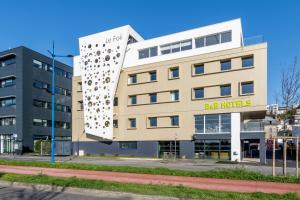 un bâtiment avec une façade qui ressemble à un bâtiment avec un bâtiment dans l'établissement B&B HOTEL Brest Centre Port de Commerce, à Brest