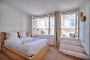 a bedroom with a bed and a large window at IMMOGROOM - Splendid Terrace - Studio - Central in Cannes