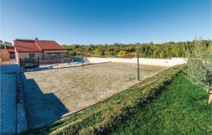 kort tenisowy z siatką na dziedzińcu w obiekcie Holiday Home Marcana 57 w mieście Marčana