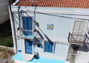 ein blau-weißes Haus mit blauen Fensterläden in der Unterkunft Casa Vacanza Giovanna nr 52 contrada Mezzacampa località Caporasocolmo Messina in Messina