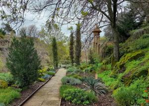 a garden with a pathway and a tower in the background at Fragas do Lobo - Casa da Azenha in Castelo Novo