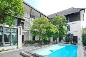 an apartment with a swimming pool in front of a building at Paraiso Hotel Chiangmai in Chiang Mai