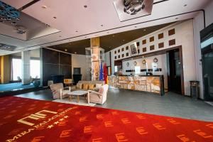 a lobby with a large red rug on the floor at Mira Palace in Al Hoceïma