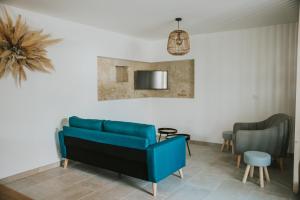 uma sala de estar com um sofá azul e uma mesa em Maison de campagne avec salle de jeux 6 personnes em Cuq