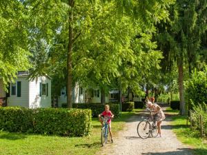 2 enfants à bord d'un vélo sur un chemin de terre avec un chien dans l'établissement Smart Home Venezia mit Terrasse, Europapark, Rulantica 15min, à Boofzheim