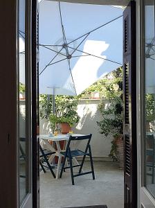 a table and chair with an umbrella on a patio at Pension Filitsa in Pylos