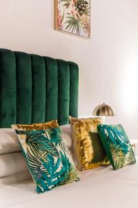 a green couch with two pillows on a bed at Bernini Collection in Rome