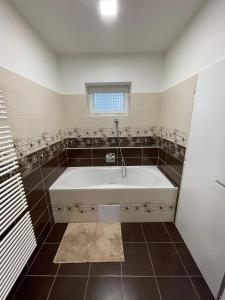 a white bath tub in a bathroom with a window at RIKY Centrum in Přestanov