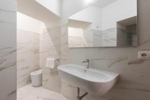 a white bathroom with a sink and a mirror at Bernini Collection in Rome +26 photos