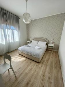 a bedroom with a bed and a chair at Aci Boutique Apartment in Acitrezza