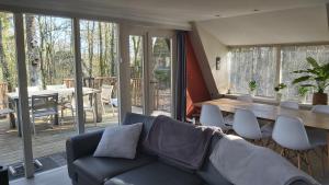 uma sala de estar com um sofá e uma mesa em Woodpecker - bungalow 29 em Durbuy