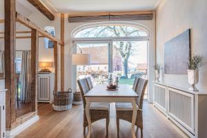 a dining room with a table and chairs and a window at HofGut Bockelkathen Apartment 5 in Lüdersburg