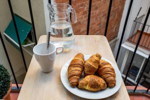 a plate of croissants and a cup of coffee on a table at Whisper-quiet Near Sagrada's Heart in Barcelona